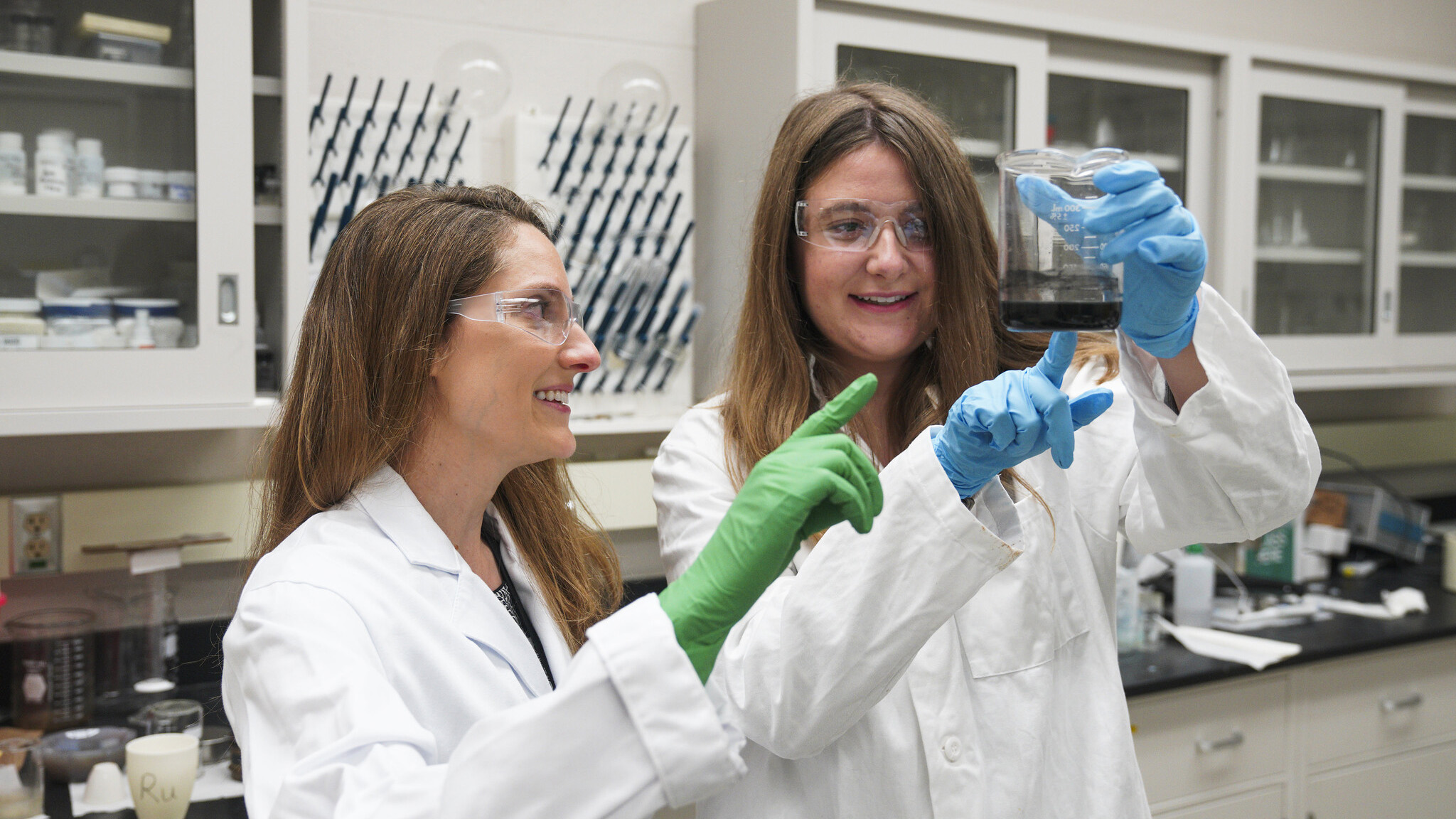 Research associate Julia Lauterbach working in the lab with mentor Candice Ellison.