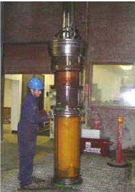 Mud hammer with jacketed rock sample outside of Terra Tek drilling simulator pressure vessel