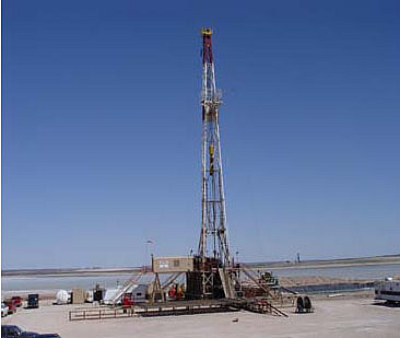 Drilling the Nash #34 well on the edge of the playa lake with a potash mine shaft in the background.