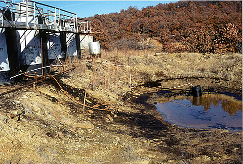 A tank battery showing produced water discharged to a holding pond in Osage County, OK. The fate of trace hydrocarbons, which leak from such holding ponds, was the focus of the research.