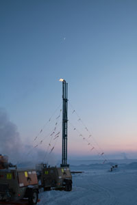 Crescent moon above Ignik Sikumi #1 flarestack; Kuparuk Operations Center (7 miles west) on horizon.