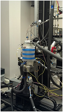 Experimental setup for geomechanical and acoustic property test pressure vessel mounted on the industrial CT scanner (Left), and CT scan images showing a sample under vertical compression.