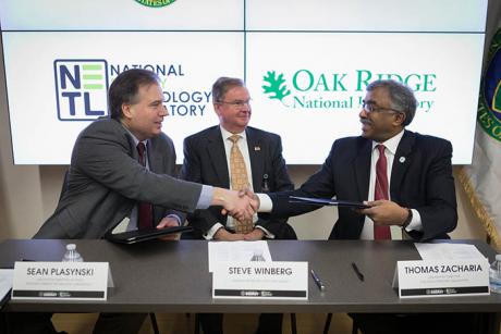 Assistant Secretary for Fossil Energy Steve Winberg looks on as Acting NETL Director Sean Plasynski (left) and ORNL Director Thomas Zacharia shake hands.