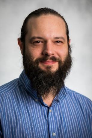 A picture of Michael Buric, a Caucasian man with a dark brown beard, brown eyes, and a buzzcut hairstyle.