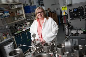 A photo pf Barbara Kutchko, a blonde woman with shoulder length hair wearing brown eyeglasses, a peach colored button-up shirt and a white lab coat.