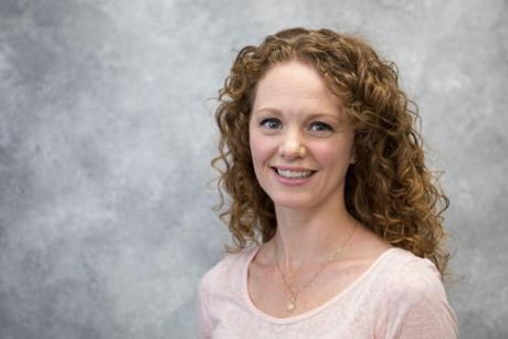 Natalie Pekney,  a Caucasian woman with green eyes and long, curly brown hair.