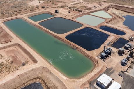 Evaporation ponds holding produced water amid the oil wells of the Permian Basin in New Mexico.