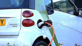 A picture of the back of a plugged in electric vehicle